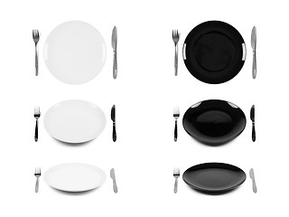 Image showing Two sets of white and black plates with fork and knife