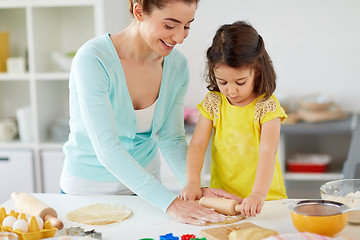 Image showing happy mother and daughter making cookies at home