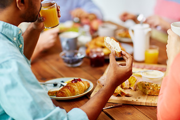 Image showing close up of man drinking orange juice with toast