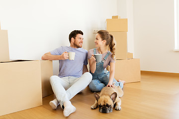 Image showing happy couple with boxes and dog moving to new home