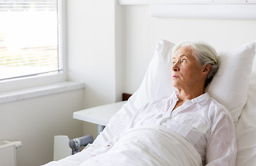 Image showing sad senior woman lying on bed at hospital ward