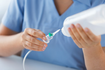 Image showing close up of nurse preparing drop counter