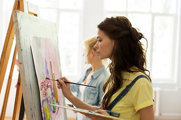 Image showing woman with easel painting at art school studio