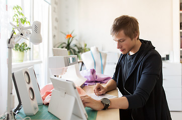 Image showing fashion designer with tablet pc working at studio