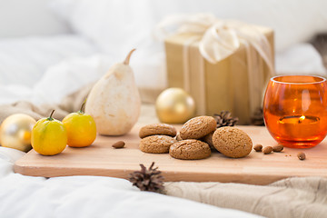 Image showing cookies, lemon, candle and christmas gift at home
