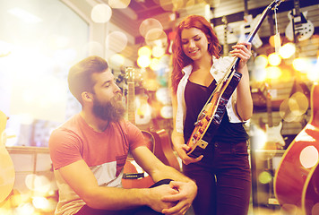 Image showing couple of musicians with guitar at music store