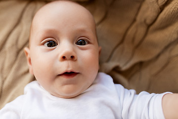 Image showing close up of sweet little baby boy lying on blanket