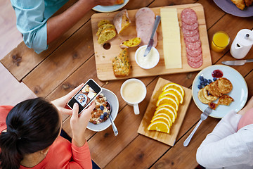 Image showing women with smartphones eating food at table