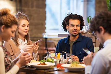 Image showing friends with smartphones at bar or restaurant