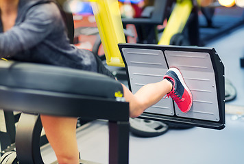 Image showing woman flexing muscles on leg press machine in gym