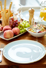 Image showing empty plate and wine glass on table with food