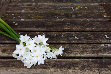 Image showing Bunch of white narcissi flowers on a rustic bench