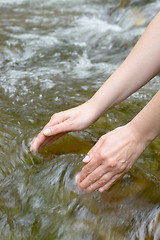 Image showing Female hands scooping water