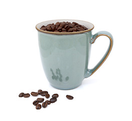 Image showing Coffee beans in green mug and spilled beside