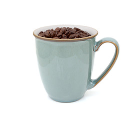 Image showing Green mug filled with dark roasted coffee beans