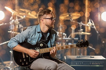 Image showing musician playing guitar at studio or music concert