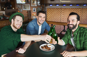 Image showing friends drinking beer in bottles at bar or pub