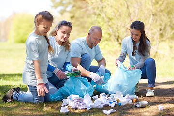 Image showing volunteers with garbage bags cleaning park area