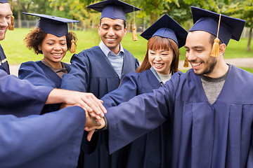 Image showing happy students or bachelors in mortar boards