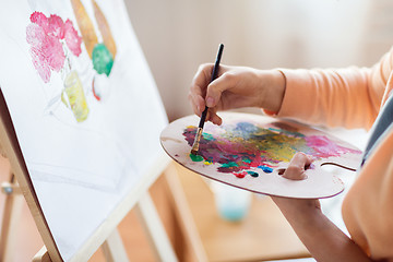 Image showing artist with palette painting at art studio