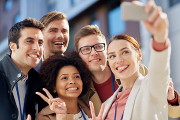 Image showing business team with conference badges taking selfie