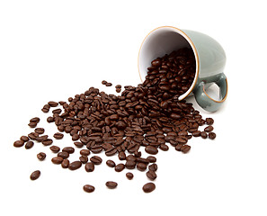 Image showing Aromatic roasted coffee beans pour from a green mug