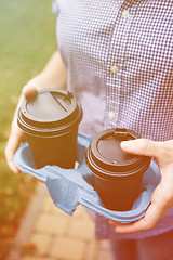 Image showing Crop person holding coffee cups