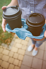 Image showing Crop person holding coffee cups