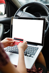 Image showing Girl shopping in car using laptop