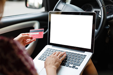 Image showing Girl shopping in car using laptop