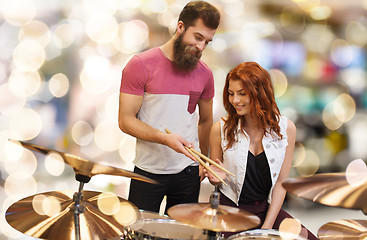 Image showing man and woman with drum kit at music store