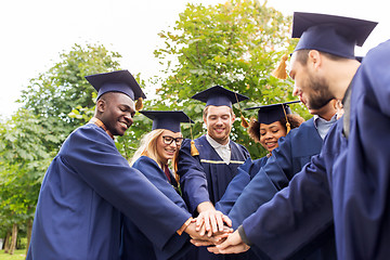 Image showing happy students or bachelors in mortar boards