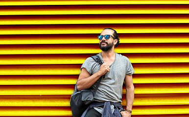 Image showing man in sunglasses with bag standing at street wall