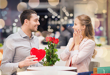 Image showing happy couple with present and flowers in mall