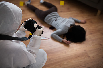 Image showing criminalist photographing dead body at crime scene