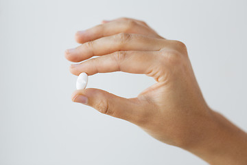 Image showing close up of hand holding medicine pill