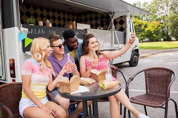 Image showing happy young friends taking selfie at food truck