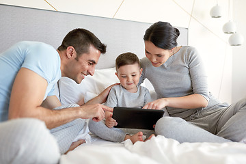 Image showing happy family with tablet pc in bed at home