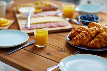 Image showing plate of croissants on wooden table at breakfast