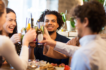 Image showing happy friends clinking drinks at bar