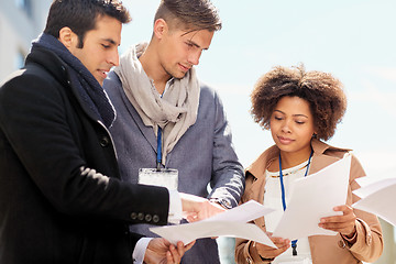 Image showing international business team with papers outdoors