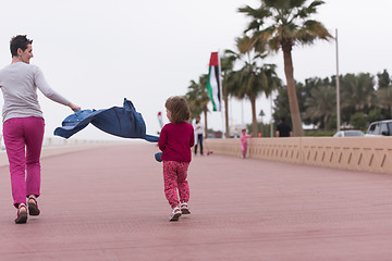 Image showing mother and cute little girl on the promenade by the sea