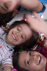 Image showing kids  blowing confetti while lying on the floor