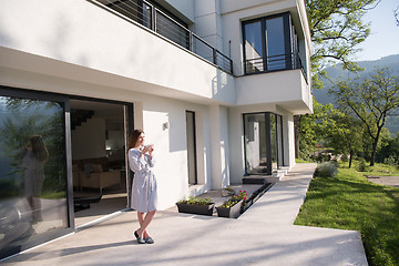 Image showing woman in a bathrobe enjoying morning coffee