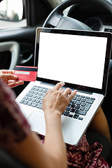 Image showing Girl shopping in car using laptop