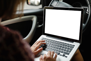 Image showing Anonymous woman browsing laptop in car