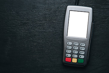 Image showing Credit card terminal on dark wooden desk