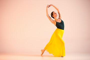 Image showing Young and incredibly beautiful ballerina is dancing at studio