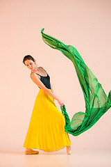 Image showing Young and incredibly beautiful ballerina is dancing at studio