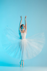 Image showing Young and incredibly beautiful ballerina is dancing in a blue studio